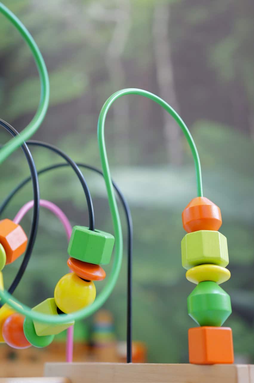 Wooden Bead Maze Toy Colorful Educational Children Play Green Background - state-of-the-art medical facility at Healers Clinic Dubai