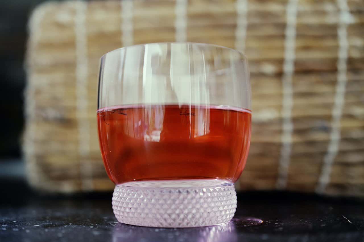 Herbal Drink Hibiscus Tea Red Orange Textured Glass Frosted Base Closeup - integrative healthcare treatment at Healers Clinic Dubai