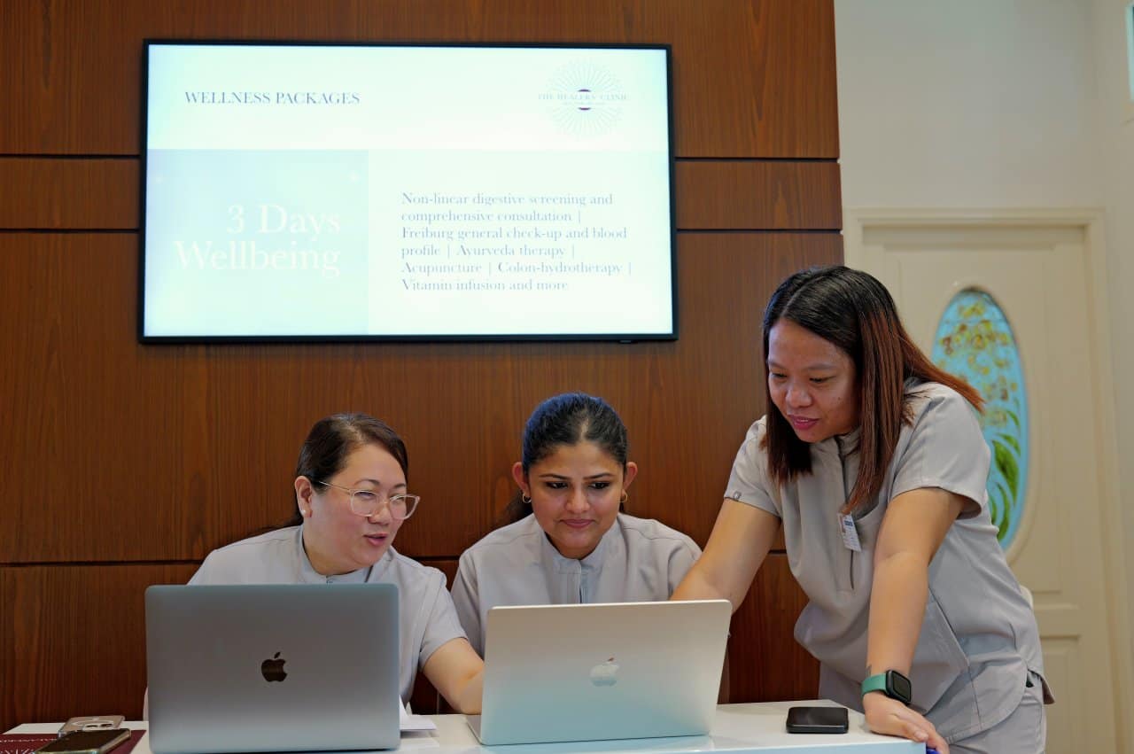 Health Clinic Staff Wellness Packages Laptops Team Meeting - our qualified healthcare team at Healers Clinic Dubai